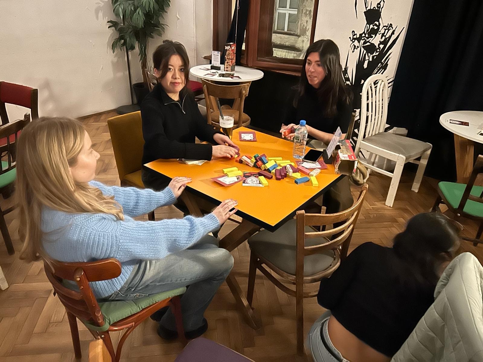 Photo of three students playing board game during event